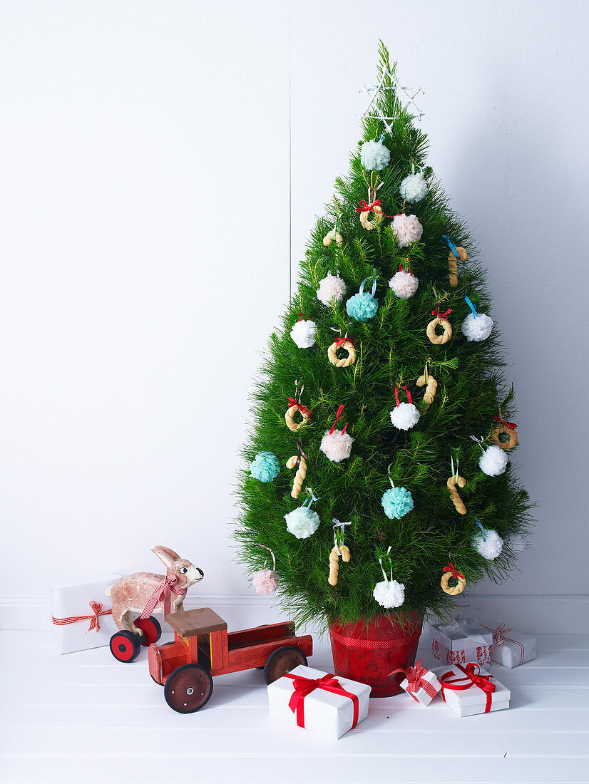 Weihnachtsbaum mit bunten Pompons und Gebäckkringeln