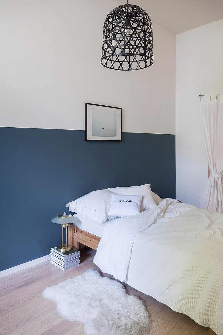 Doppelbett im Schlafzimmer mit zweifarbiger Wand