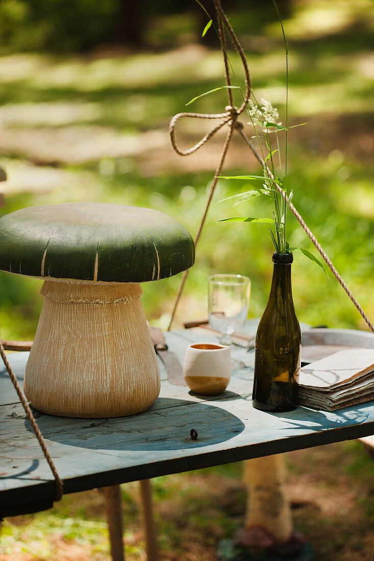 Deko-Pilz auf einem hängenden Tisch im Grünen