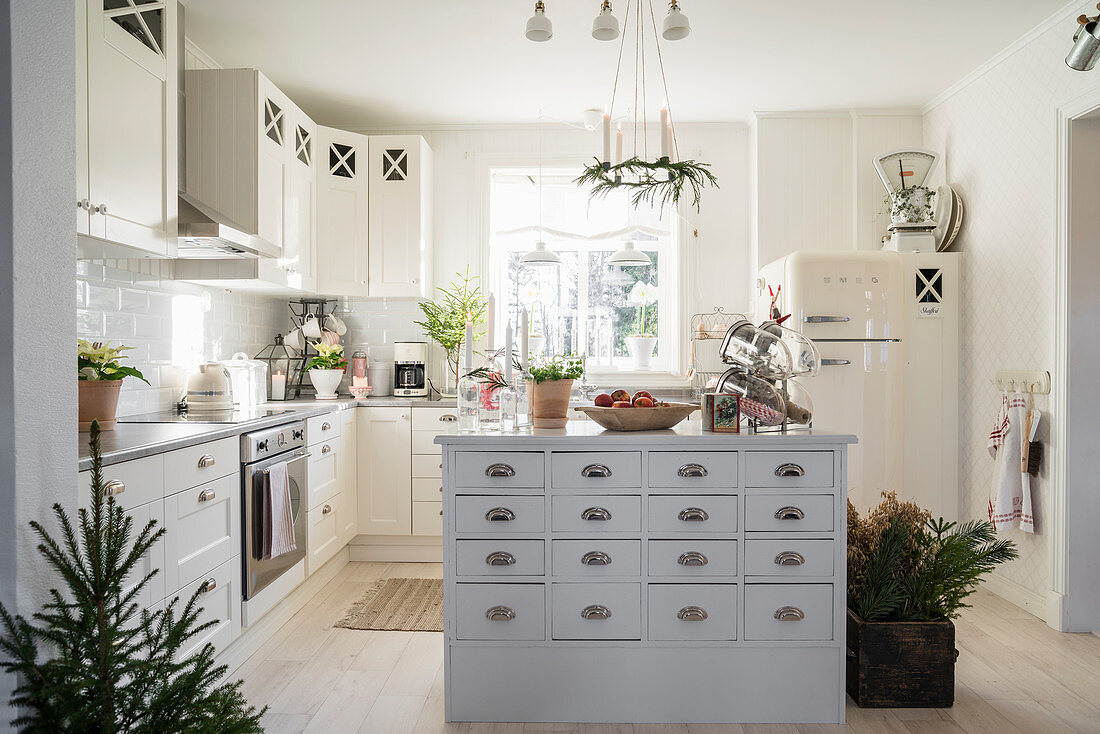 Island counter and Christmas decorations in bright fitted kitchen