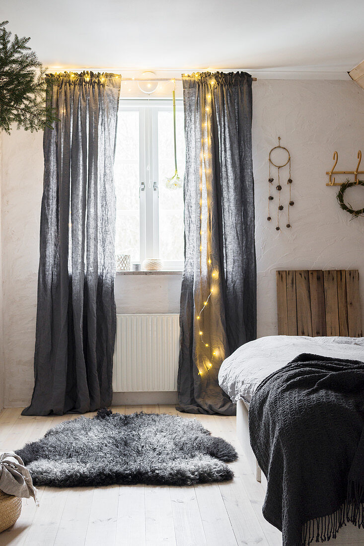 Fairy lights on grey curtains in bedroom