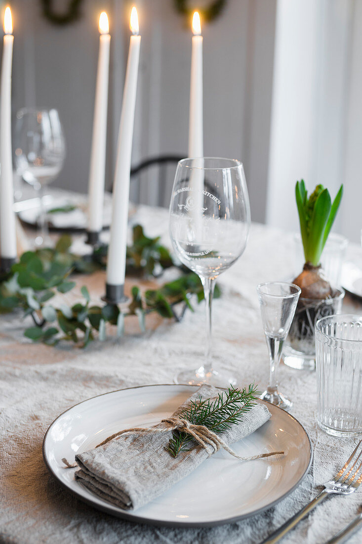 Linen napkin tied with fir sprig and spring on set table