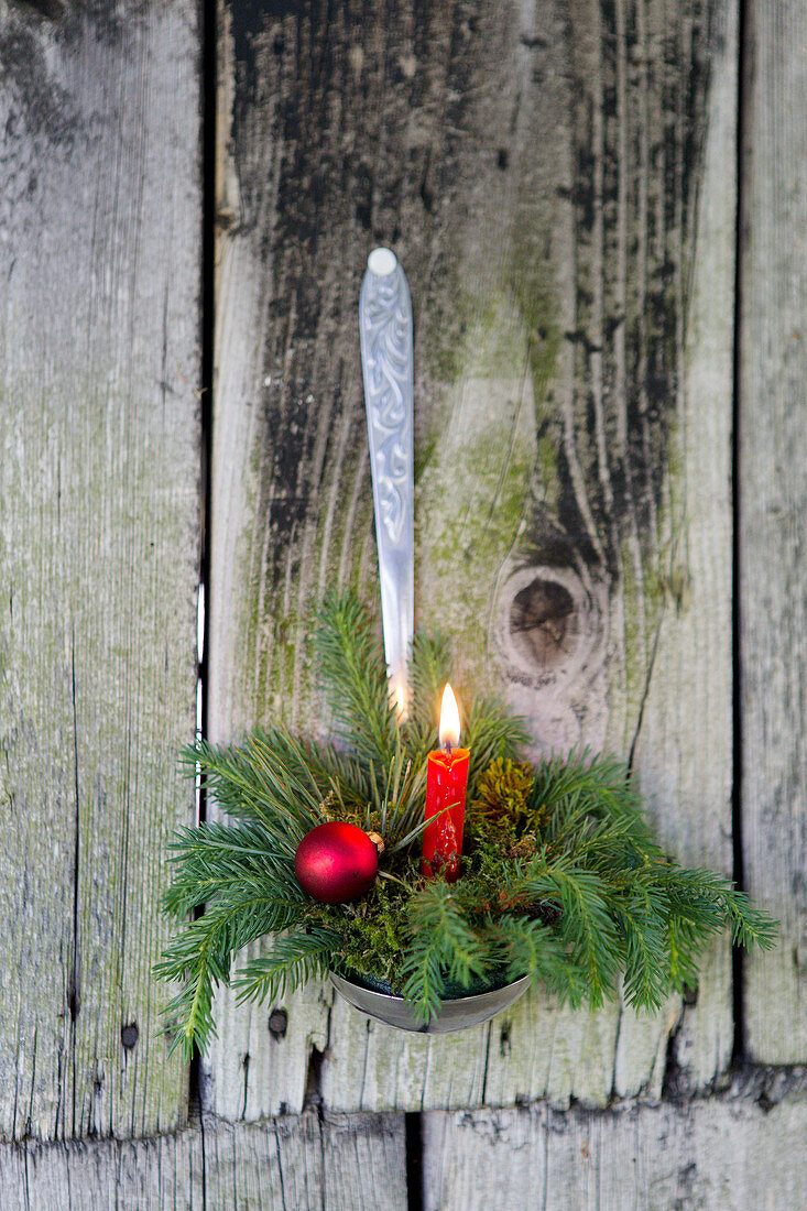 Weihnachtliches Gesteck mit Kerze in einem Schöpflöffel