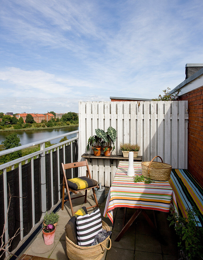 Tisch, Sitzmöbel und Kissen im Streifen-Look auf Balkon