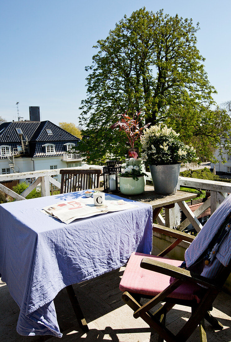 Tisch mit lila Tischdecke und Stühle auf Balkon