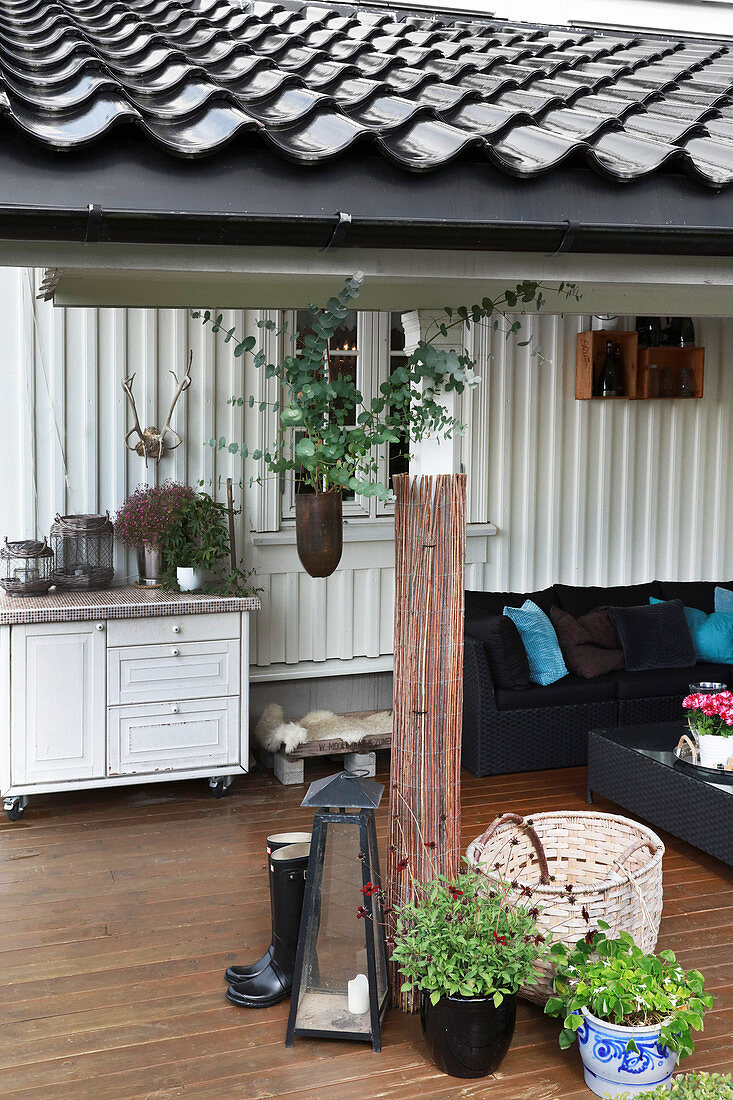 Überdachte Terrasse mit Sofa und ländlicher Deko
