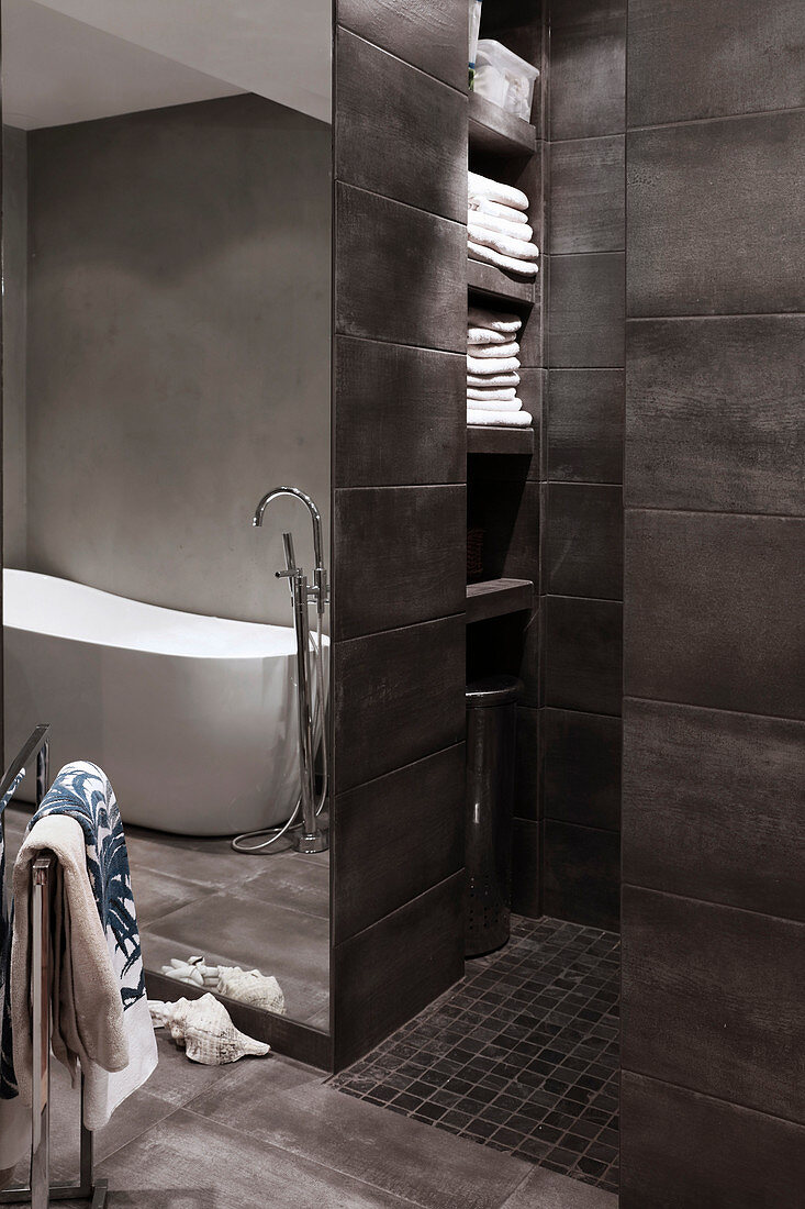 Modernes Bad in Grau mit offener Dusche und eingebauten Regalen