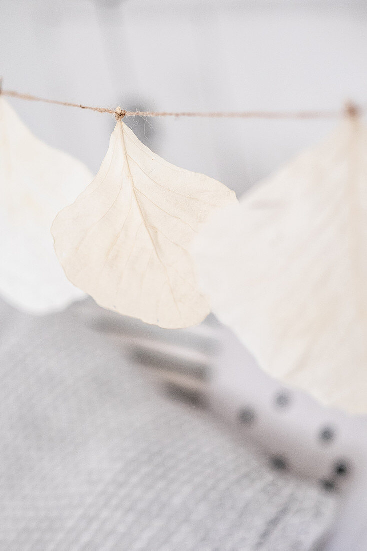 DIY-Girlande aus weiß besprühten Blättern