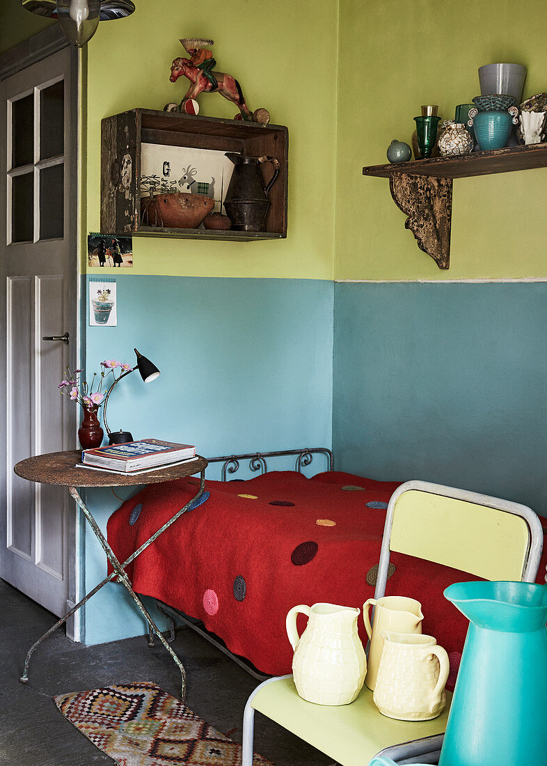 Tagesbett und Flohmarktmöbel vor zweifarbiger Wand