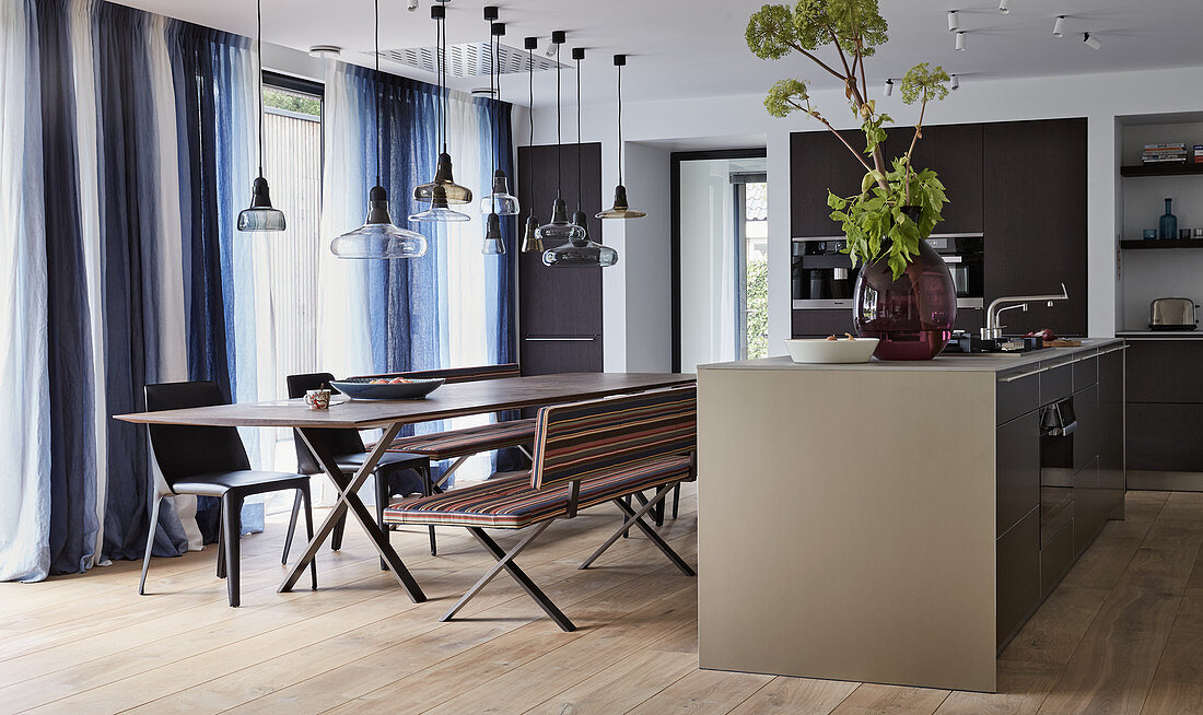 Langer Esstisch mit Bänken und Stühlen in moderner Wohnküche