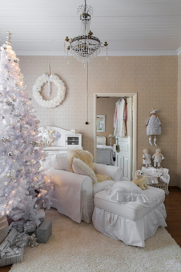 Weißer Weihnachtsbaum und weißer Hussensessel mit passendem Fußhocker