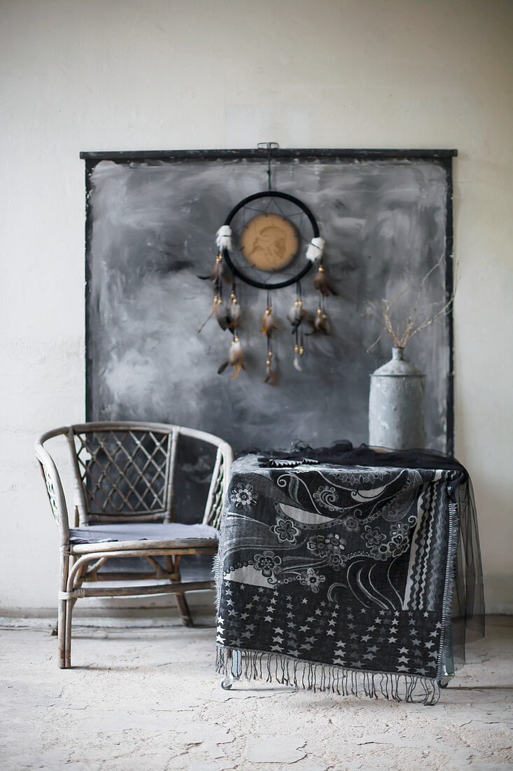 Dreamcatcher and painted wall hanging above table