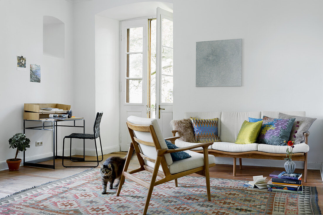 Wohnzimmer mit Schreibtisch und skandinavischen Sitzmöbeln
