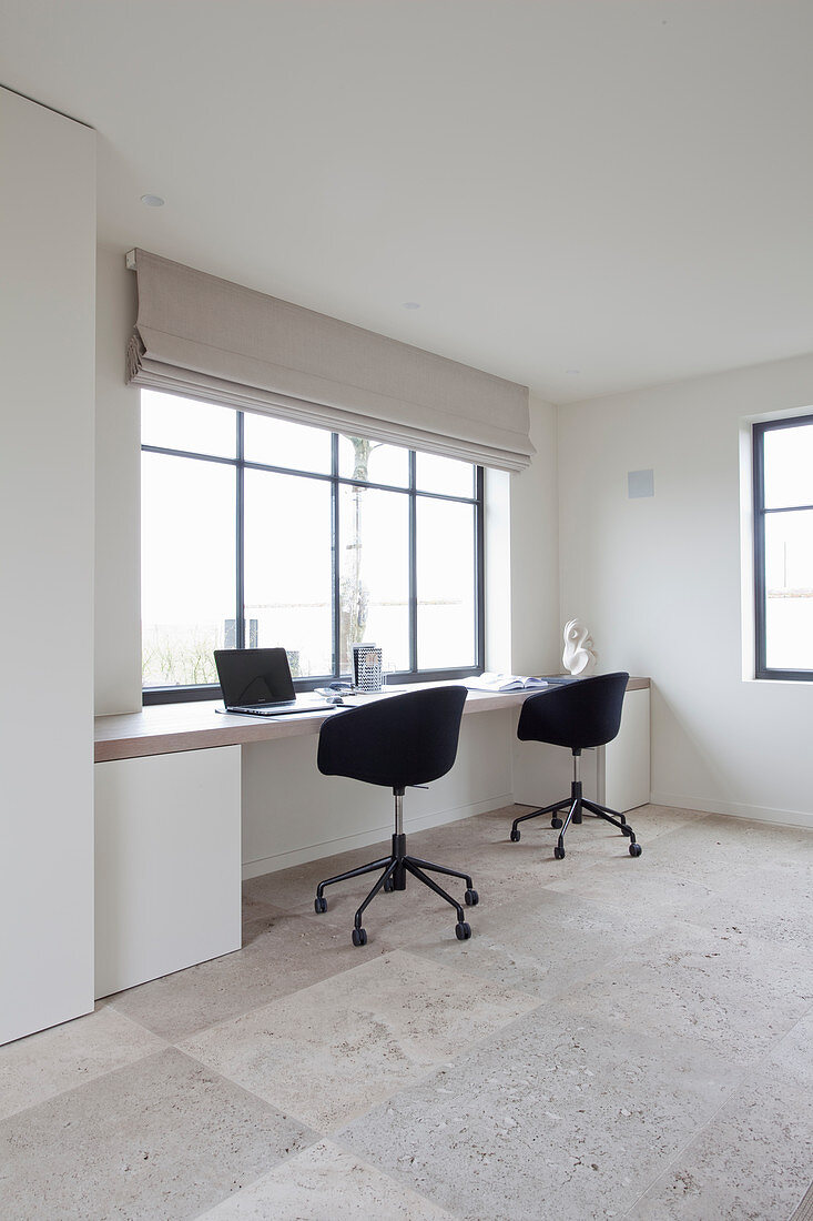 Two office chairs at fitted desk below window