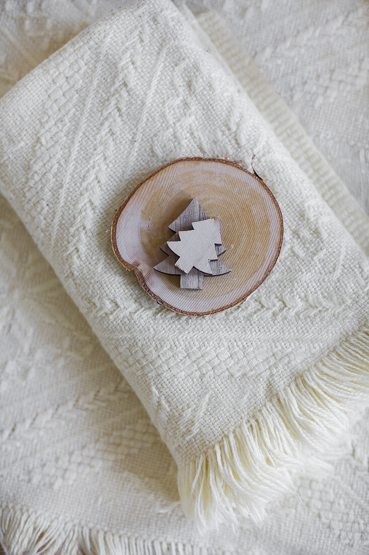 Wooden Christmas trees and slice of tree trunk on wooden blanket