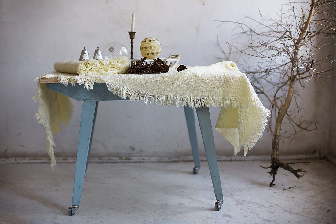 Woollen blankets and wintry accessories on blue wooden table