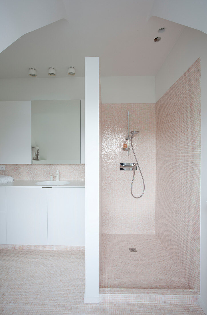 Tiled shower area in simple bathroom with white fittings