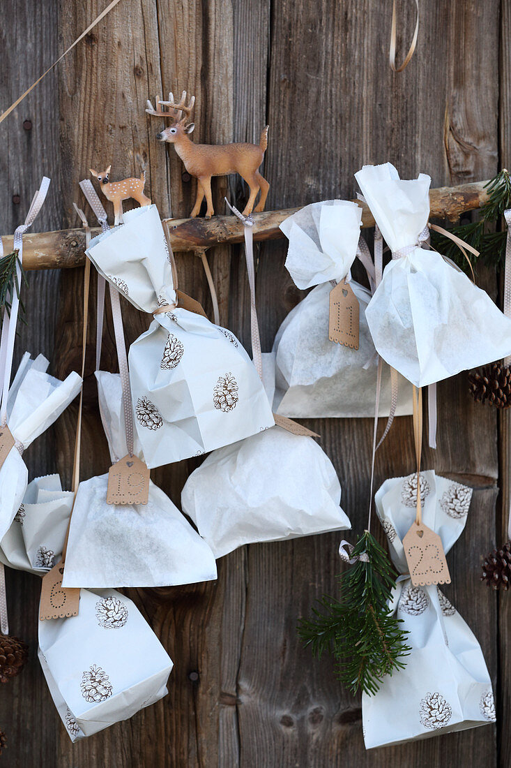 Advent calendar made from sandwich bags on rustic board wall
