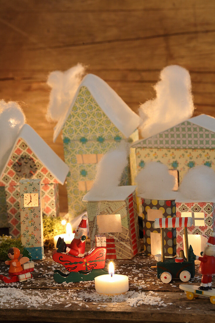 Beleuchtetes Weihnachtsdorf mit pastellfarbenen Papphäusern