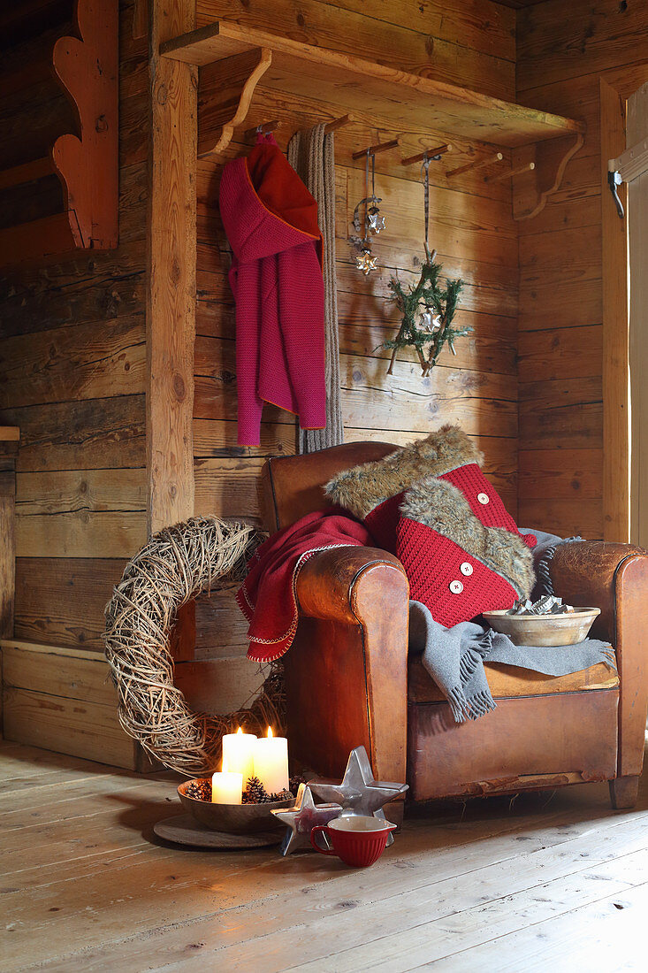 Vintage leather armchair and Christmas decorations in rustic wooden cabin