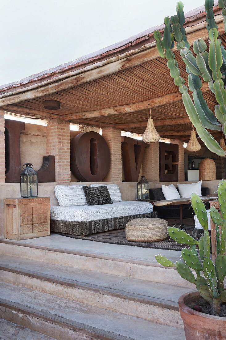 Blick auf überdachte Terrasse mit eleganten Sitzmöbeln
