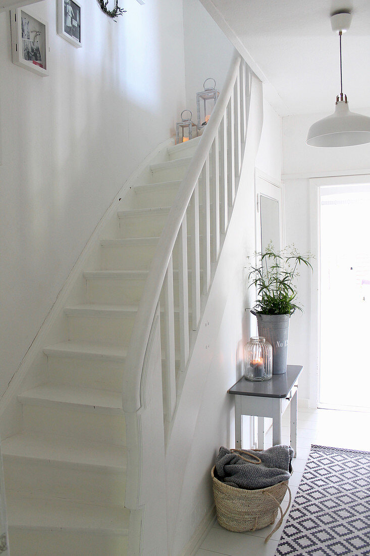 Konsolentisch und Teppichläufer in weißem Treppenhaus