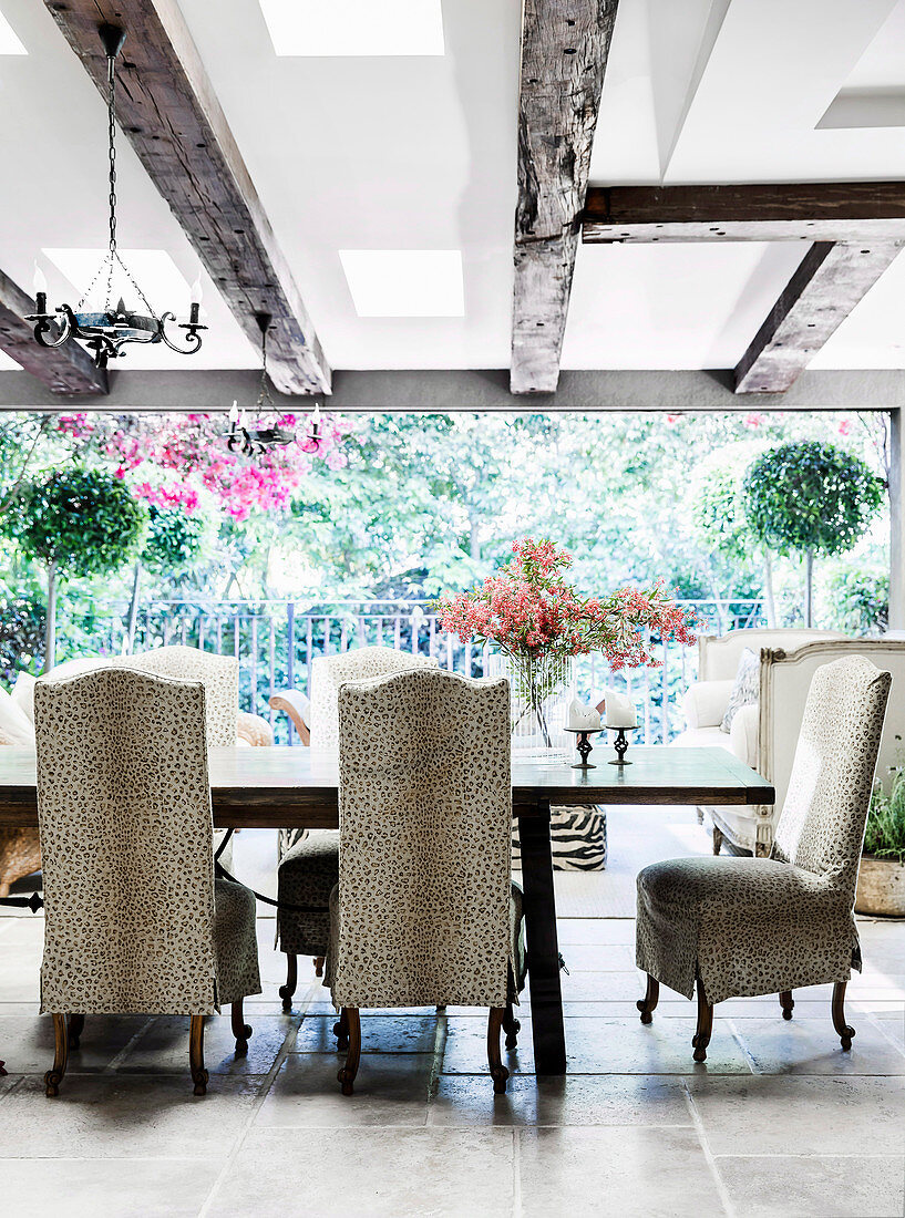 Covered chairs with animal print and dining table in an open dining room