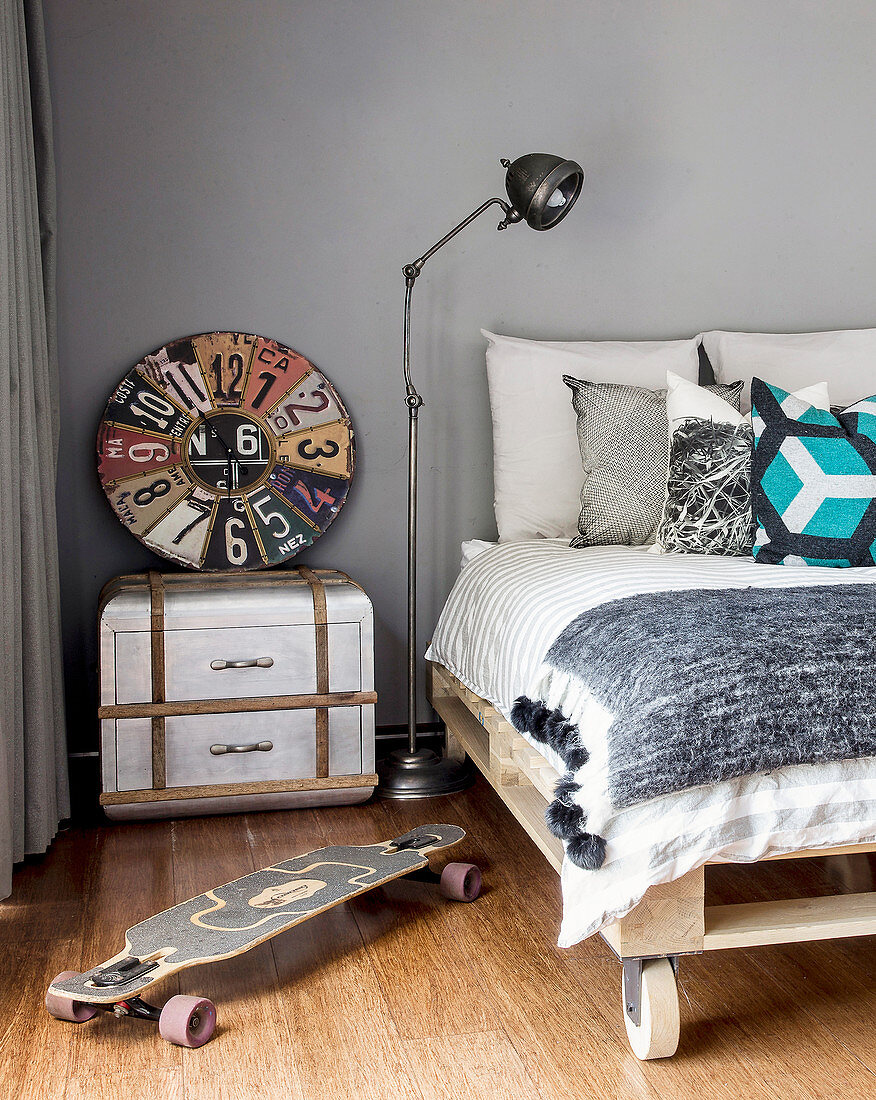 Pallet bed on castors, vintage accessories and skateboard in teenager's bedroom