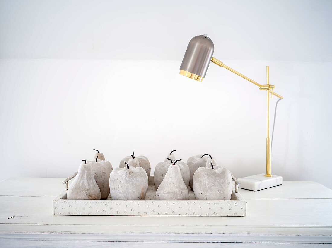 Arrangement of concrete apples and pears on tray