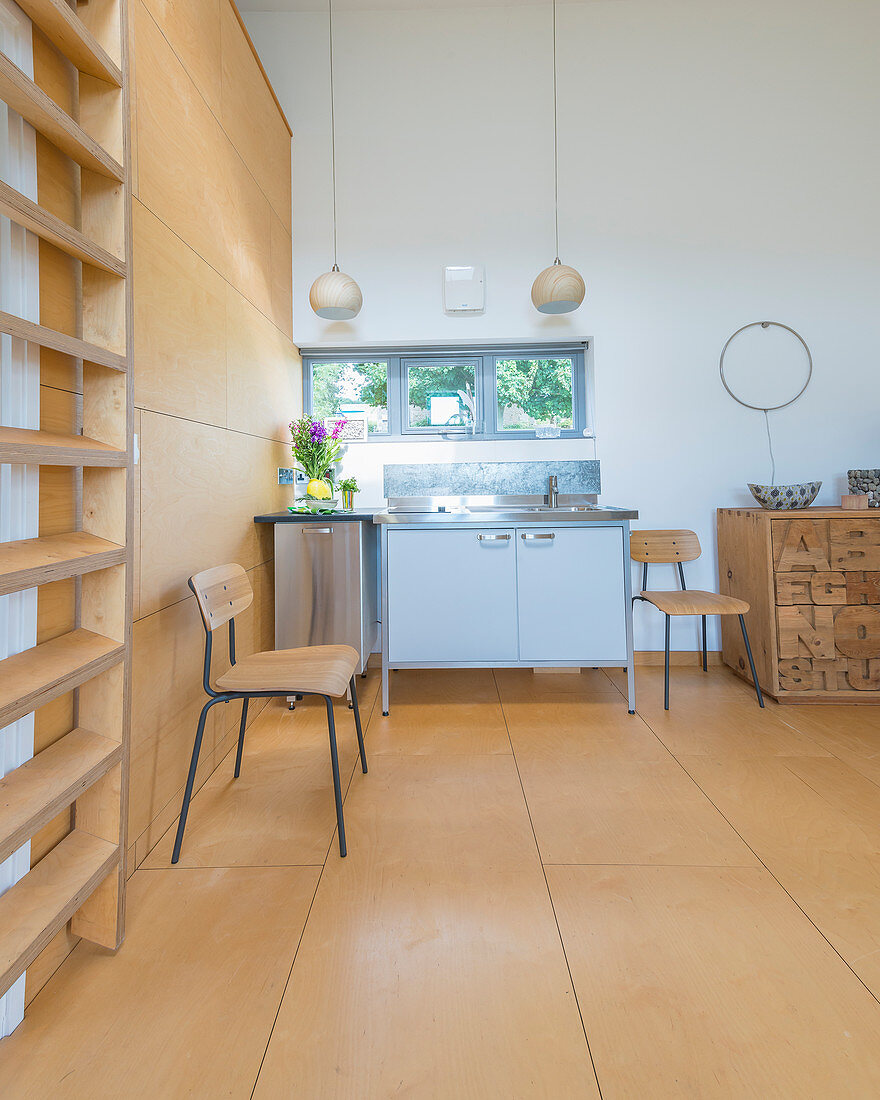 Mini-Küche im offenen Wohnraum mit Sperrholzboden