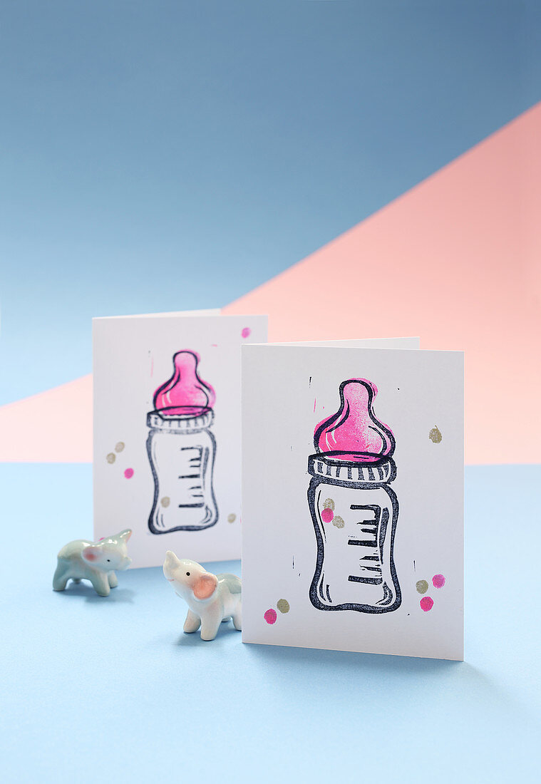 Hand-made invitation cards to a baby shower with a baby bottle motif