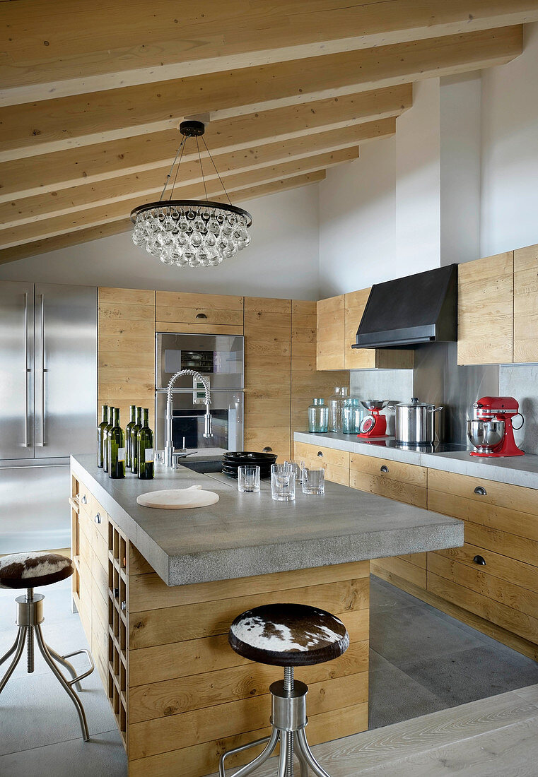 Moderne Küche mit Holzfronten und Betonarbeitsplatten im Chalet