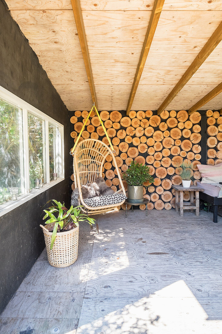 Hängesessel im urigen Gartenhaus mit Holzwand