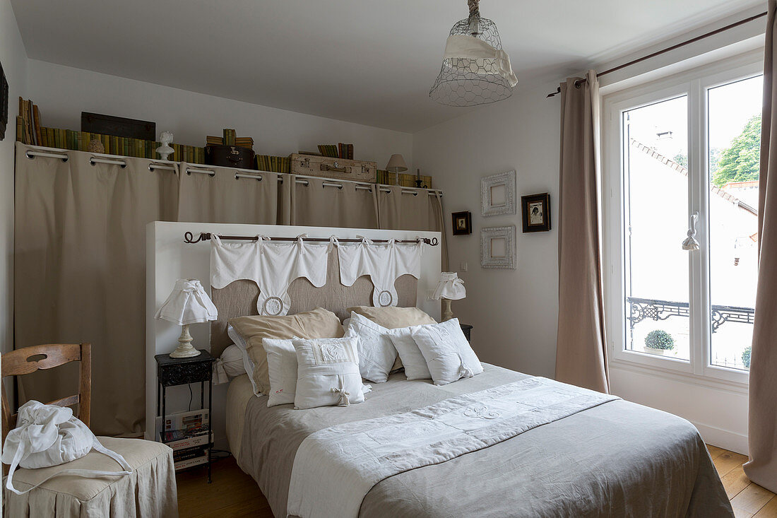 Schlafzimmer in Naturtönen mit Doppelbett und begehbarer Garderobe