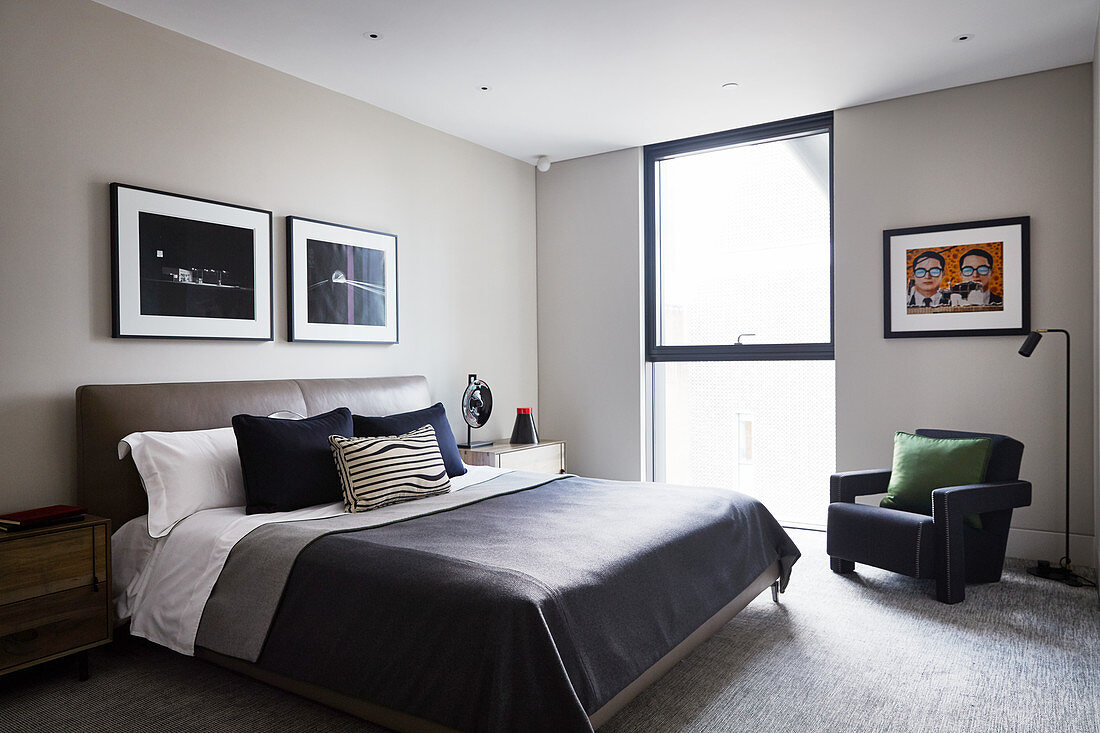 Doppelbett mit Leder-Betthaupt und Sessel in elegantem Schlafzimmer