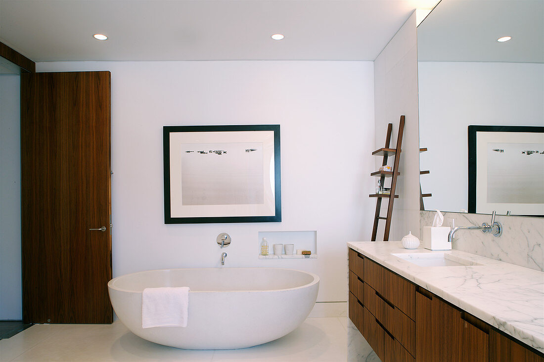 Frei stehende Badewanne und Waschtisch mit Marmorplatte in elegantem Badezimmer