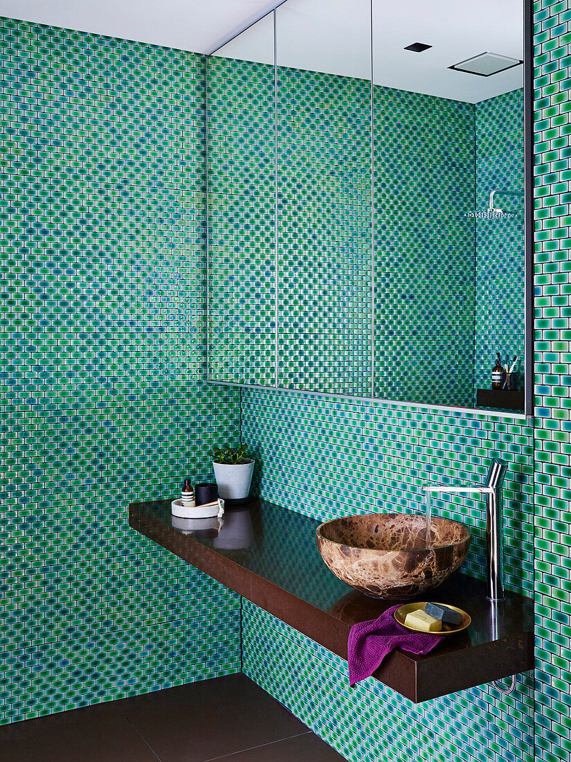 Mirror cabinet and vanity in the bathroom with mosaic tiles in green tones