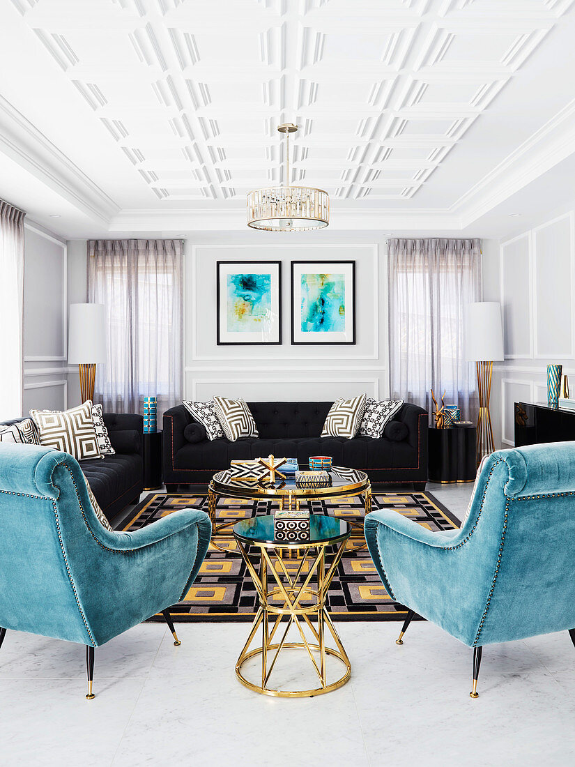 Schwarze Polstersofas und türkisblaue Sessel mit Samtbezug in luxuriösem Wohnzimmer