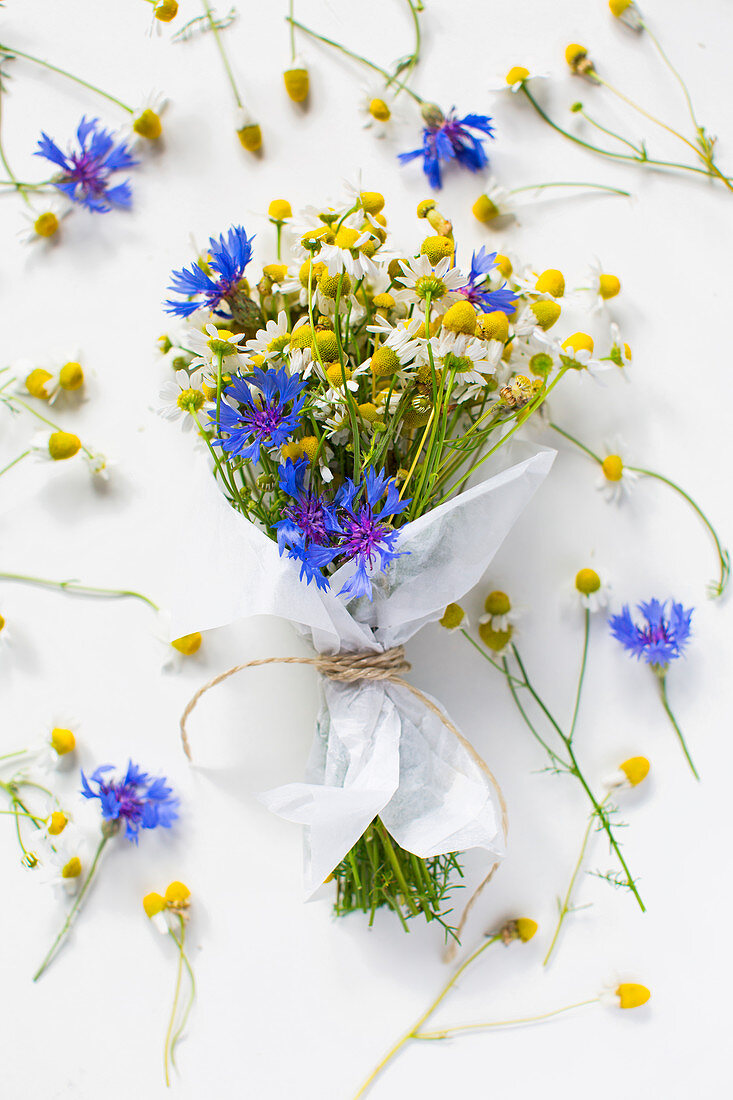 Posy of chamomile and cornflowers wrapped in paper