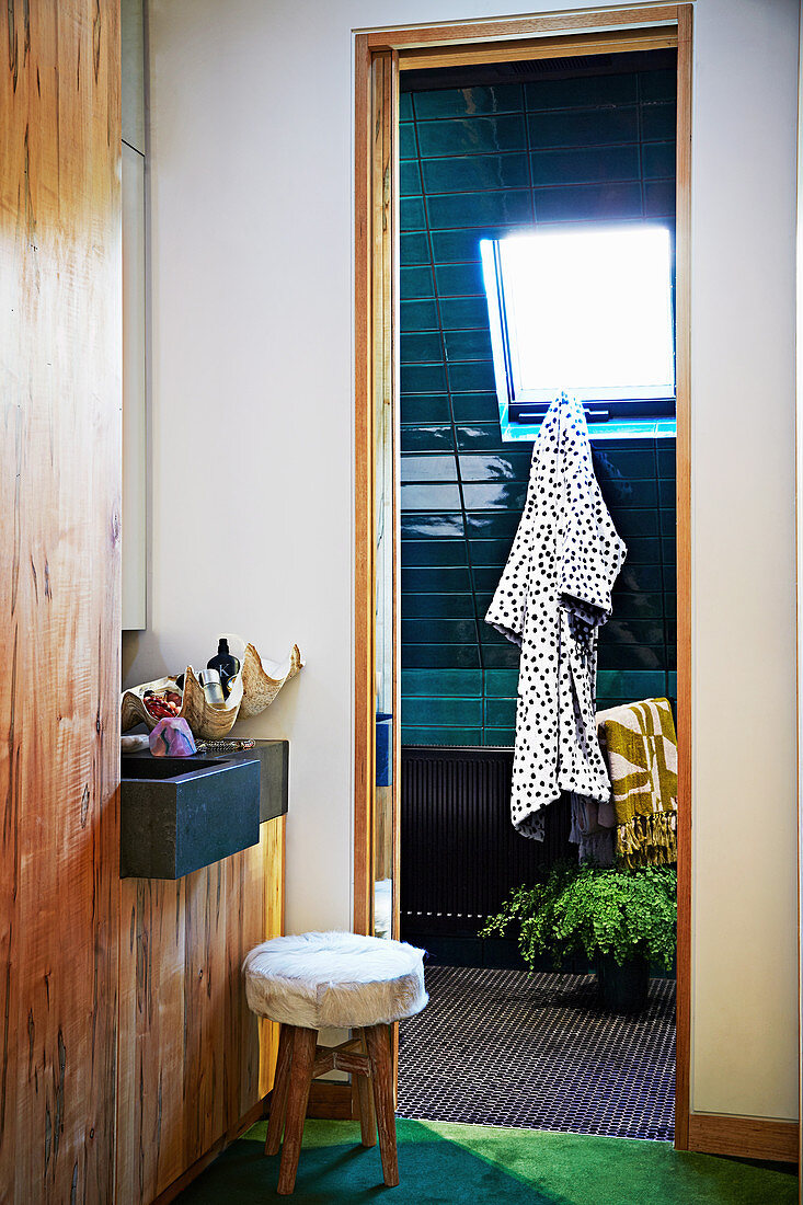 Blick ins Badezimmer mit grünen Keramikfliesen und Dachfenster