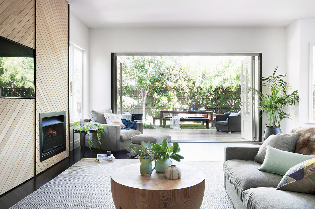 Modernes Wohnzimmer in Naturtönen mit Blick in den Garten