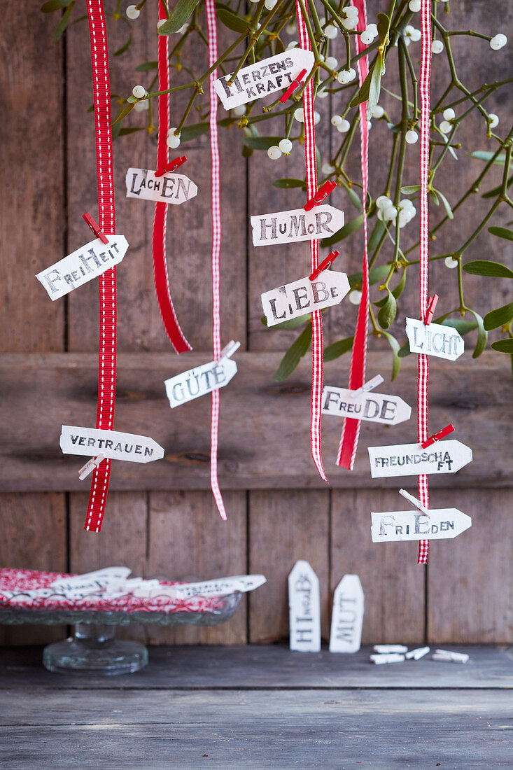 Gute Wünsche zum Weihnachtsfest auf Kärtchen geschrieben aufgehängt an Schleifenbändern