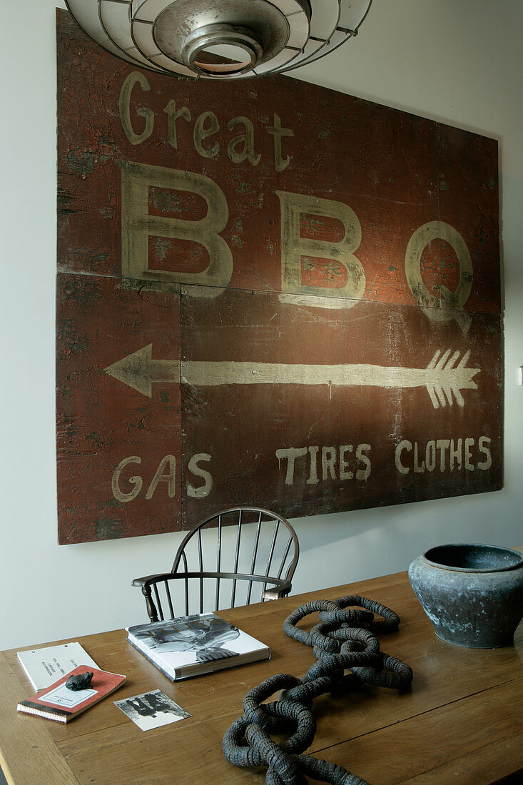 Altes Schild für Barbecue über dem Holztisch mit Kunsobjekt