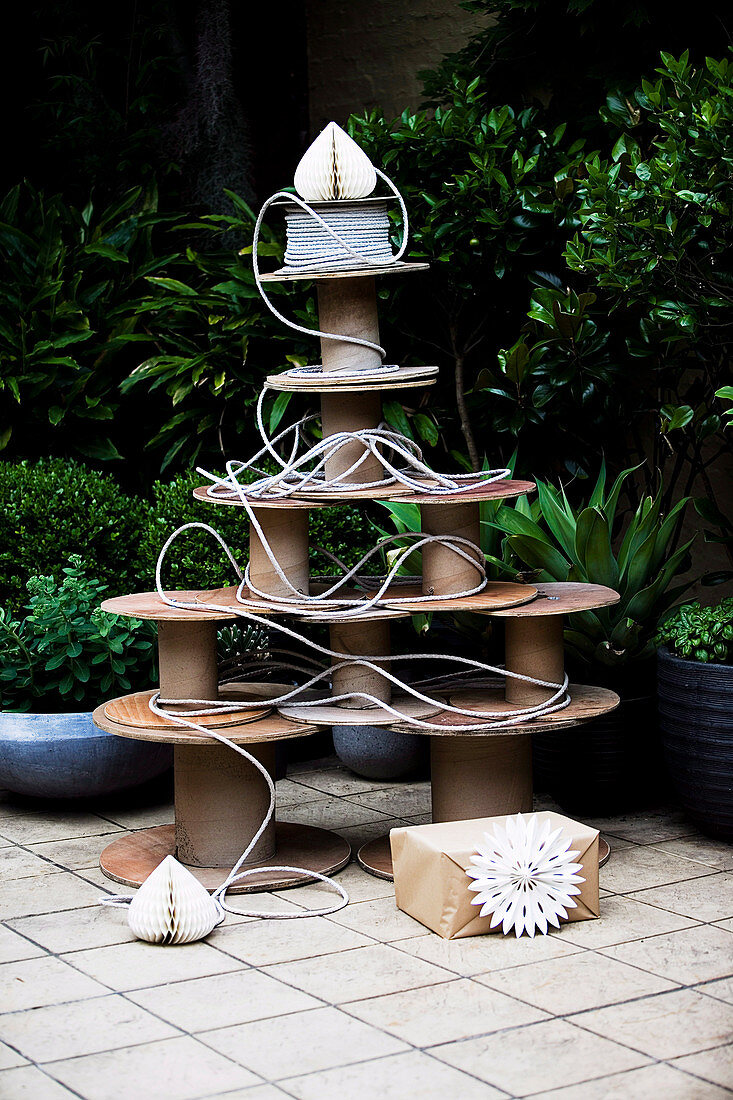 Large, old wooden spools in the shape of a Christmas tree arranged on the terrace