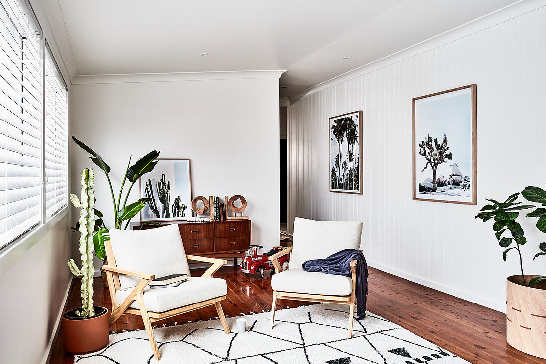 Armlehnstühle mit Polsterauflage und Zimmerpflanzen in hellem Zimmer