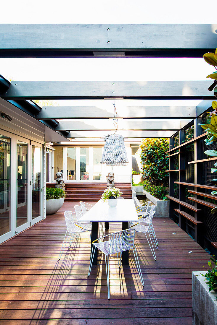 Moderne Gartenmöbel auf der überdachten Terrasse mit Holzdeck