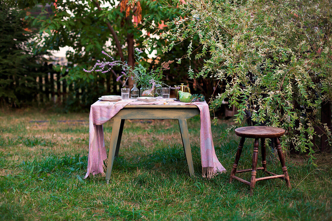 Gedeckter Tisch im spätsommerlichen Garten