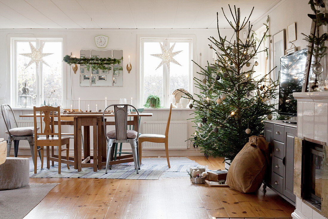 Ländliches Wohnzimmer mit Weihnachtsdekoration und geschmücktem Baum