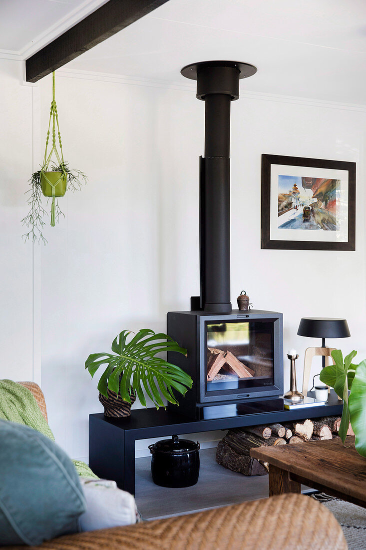Black fireplace with bench and houseplants in the living room