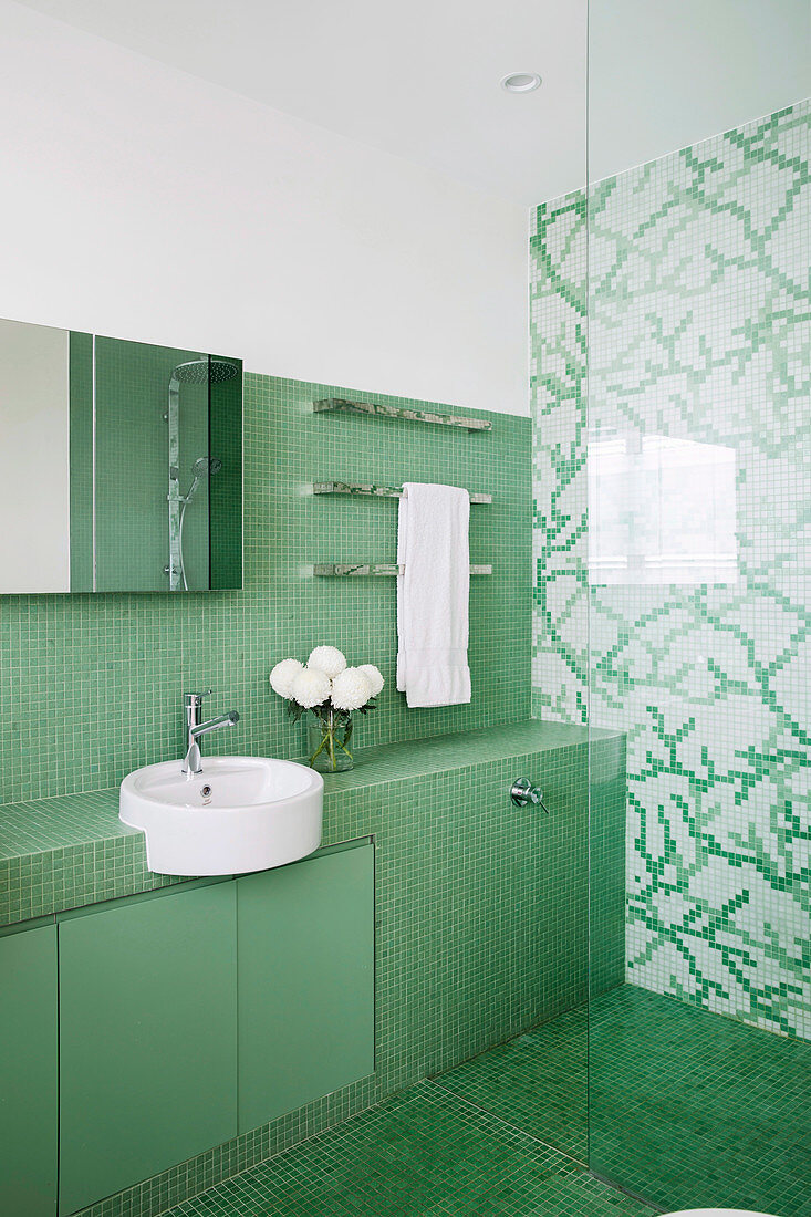 Glance into the bathroom with green and green and white mosaic tiles